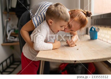 Little boy and mother exploring insect on table Little boy and mother exploring insect on table 133553312