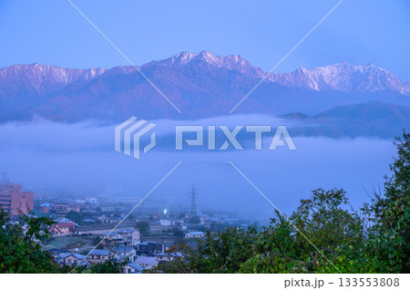 朝霧の漂う大町市街地と夜明けの後立山連峰 133553808