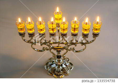 Glowing candles light up beautiful menorah on Jewish holiday its intricate during festive Hanukkah celebration Glowing candles light up beautiful menorah on Jewish holiday its intricate during festive Hanukkah celebration 133554738