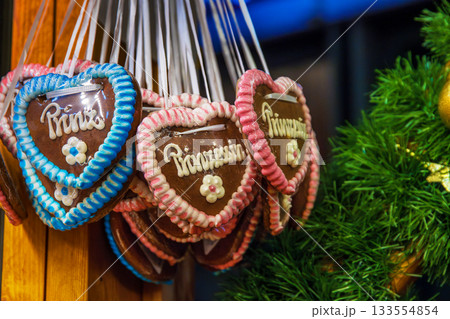 Princess themed lebkuchen hearts. A closeup of colorful heart shaped gingerbread decorated with the word prinzessin hanging at festive christmas market stall Princess themed lebkuchen hearts. A closeup of colorful heart shaped gingerbread decorated with the word prinzessin hanging at festive christmas market stall 133554854