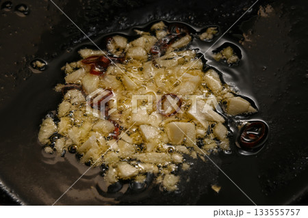 ニンニクと唐辛子をオリーブオイルで炒める様子 133555757