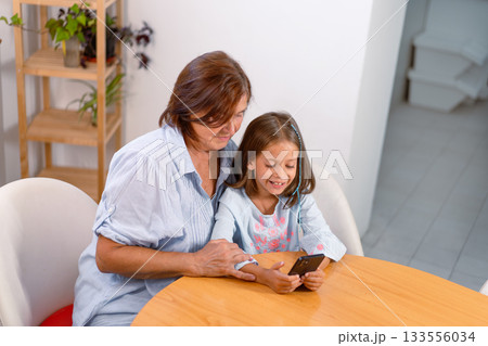 Grandmother and granddaughter using smartphone 133556034