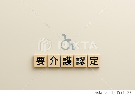 要介護認定を表す木ブロックと車椅子アイコンのミニマル背景 133556172