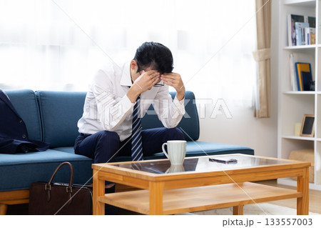ソファーに座り頭を抱えている男性 133557003