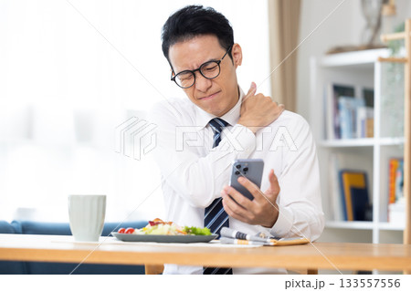 出勤前　スマホを見ながら食事をする男性 133557556