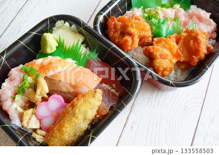 海鮮丼と唐揚げ丼が並ぶテイクアウト弁当2種セット。 133558503