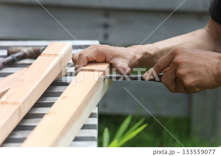 ノミで材木を削る男性 133559077