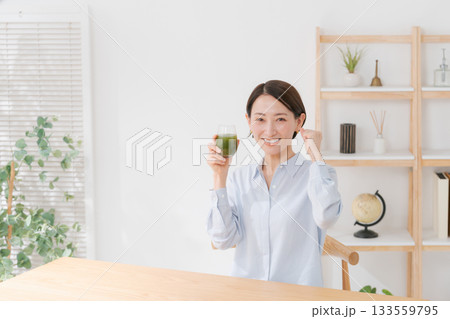 青汁を飲んでガッツポーズをする女性 133559795