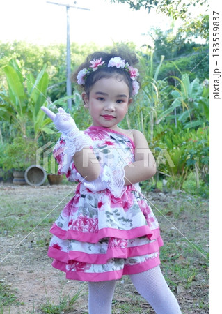 Portrait of a little girl in a pink dress and a red flower Portrait of a little girl in a pink dress and a red flower 133559837