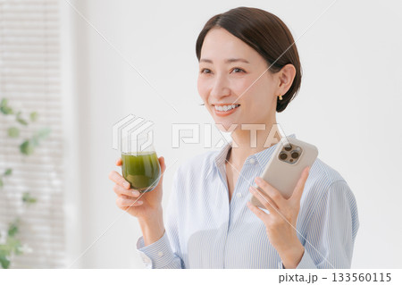 青汁とスマホを持つ女性 133560115