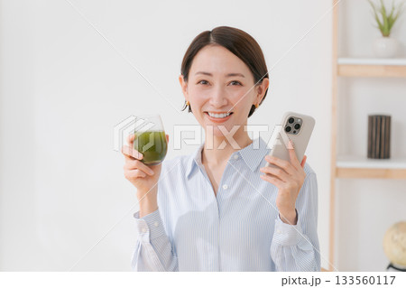 青汁とスマホを持つ女性 133560117