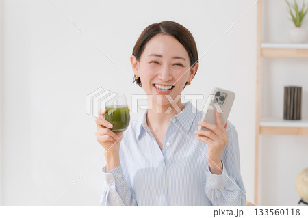 青汁とスマホを持つ女性 133560118