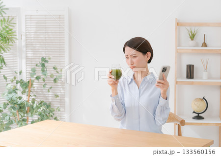 青汁とスマホを持つ女性 133560156