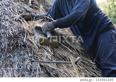 茅葺き屋根の修繕をする職人 133561104