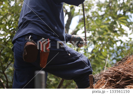 茅葺き屋根に足場を作る職人 133561150