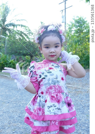 Cute Asian girl wearing flower dress and handkerchief in a park 133561368