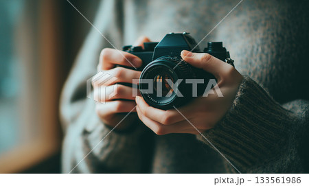 セーター姿の人物がカメラを両手で構える「生成AI」 133561986