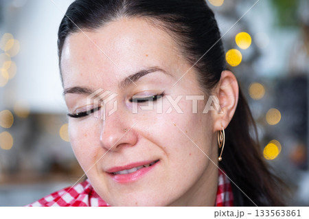A woman has long extended eyelashes in a close-up with rhinestones. Preparing the image for the holiday A woman has long extended eyelashes in a close-up with rhinestones. Preparing the image for the holiday 133563861