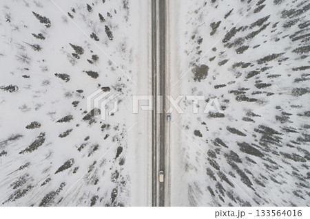 Aerial view of the highway against the backdrop of a winter forest, top dawn 133564016