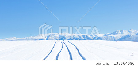 青空と圧雪道路に車が通った跡がある冬の北海道美瑛町の丘の道 133564686