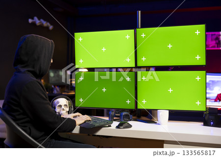 Hacker doing ransomware attacks using isolated screen multi monitor setup to hold company systems hostage and demand money. Man using chroma key computer, hacking enterprise networks, encrypting files 133565817
