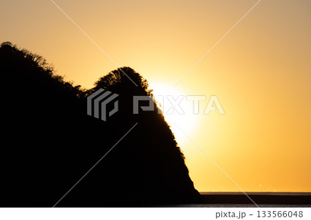 夕焼けに照らされれる島の木々のシルエット 夕焼けに照らされれる島の木々のシルエット 133566048