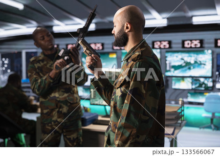 Middle Eastern army solder packing pistol able to engage targets at extended range with accurate, lethal fire. Armed forces troops reloading guns, preparing to start assault mission during global war 133566067