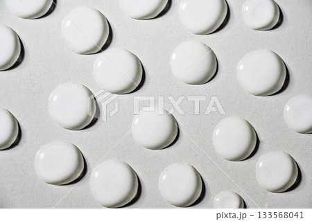 Closeup view of white fluid drops on a textured grey background 133568041