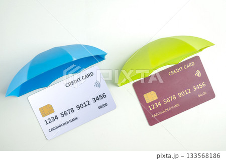 Top view of debit or credit card with colorful umbrella on a white background. Mockup or template. Flat lay. Concept of Security, finance, and business 133568186