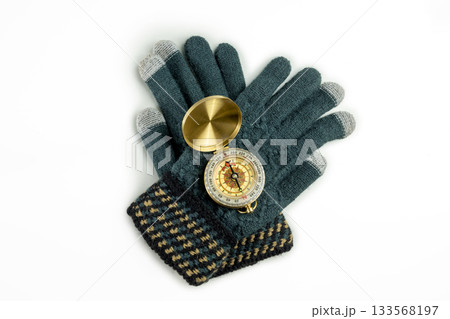 Antique compass and winter gloves on a white background. Concept of travel Antique compass and winter gloves on a white background. Concept of travel 133568197