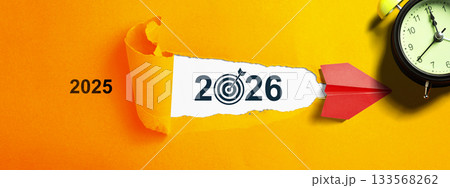 Red paper airplane flying from the year 2025 towards the year 2026 on a colored background. Happy New Year concept or Celebration. 2026 Goal Target Red paper airplane flying from the year 2025 towards the year 2026 on a colored background. Happy New Year concept or Celebration. 2026 Goal Target 133568262