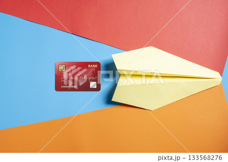Credit card and yellow paper airplane on a colorful background. Concept of finance and travel 133568276