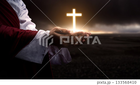 Jesus Christ raising his hand and praying with the Christian cross with dark dramatic sky background. Concept of Christianity, religious, faith, Jesus, or belief 133568410