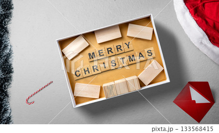 Greeting of Merry Christmas text with a wooden block in a gift box. Mockup or Copy space. Holiday greetings or winter themes. Concept of the Merry Christmas celebration 133568415