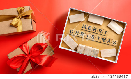 Greeting of Merry Christmas text with a wooden block in a gift box. Mockup or Copy space. Holiday greetings or winter themes. Concept of the Merry Christmas celebration 133568417