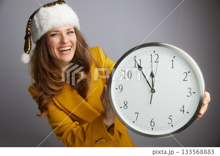 Festive Businesswoman Presenting New Year Clock 133568883