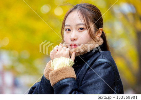 コートを着た笑顔の若い女性 コートを着た笑顔の若い女性 133569981