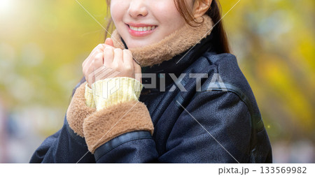コートを着た笑顔の若い女性 コートを着た笑顔の若い女性 133569982