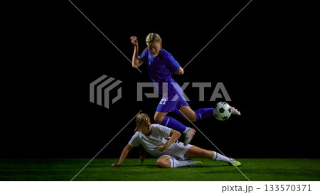 Teenage female soccer players in sliding tackle duel during active play Teenage female soccer players in sliding tackle duel during active play 133570371