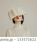 Woman resting book against face, eyes closed, wearing white sweater, relaxing on soft gray background, minimalist aesthetics 133571622