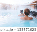 Tourists relaxing in steamy geothermal spa, enjoying therapeutic waters amid tranquil natural surroundings with soft mist enveloping the scene 133571623
