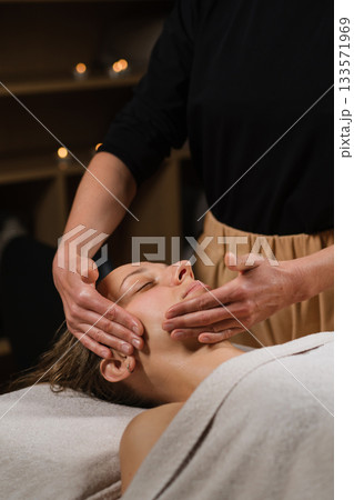Relaxing facial massage session in a spa setting with a focus on skin rejuvenation and stress relief during evening hours Relaxing facial massage session in a spa setting with a focus on skin rejuvenation and stress relief during evening hours 133571969