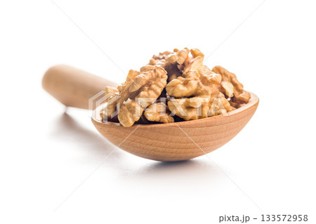 Peeled walnut kernels in wooden scoop isolated on white background. Peeled walnut kernels in wooden scoop isolated on white background. 133572958