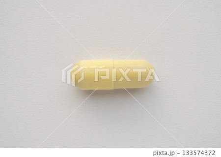 Yellow medicine vitamin pill capsule on white background Yellow medicine vitamin pill capsule on white background 133574372