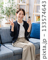 ソファーでスマホを操作する女性　ピース 133574643