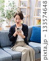 ソファーでスマホを操作する女性　驚く 133574648