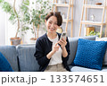 ソファーでスマホを操作する女性 133574651