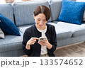 ソファーでスマホを操作する女性 133574652