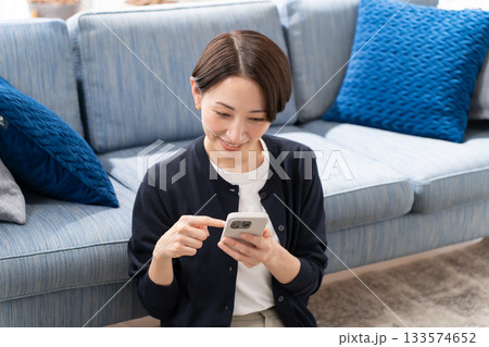ソファーでスマホを操作する女性 133574652