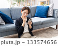 ソファーでスマホを操作する女性　悩む 133574656